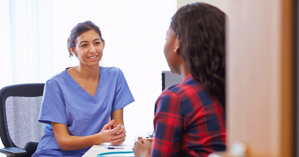 medical professional talking to a young woman about her ultrasound results